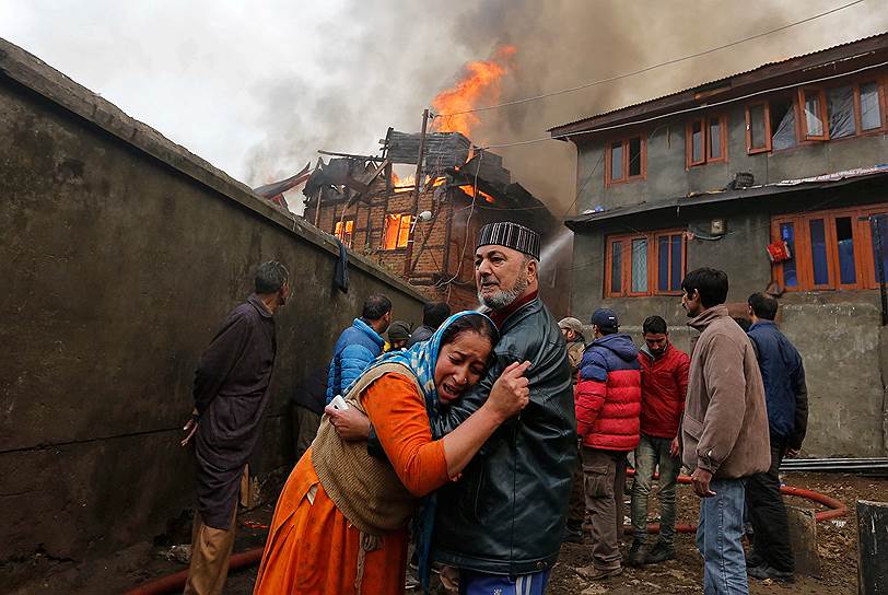 Сринагар, Индия. Местный житель утешает женщину, чей дом сгорел во время крупного пожара в жилом районе города