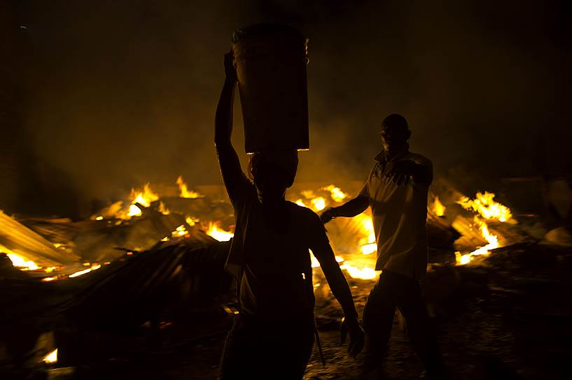 Порт-о-Пренс, Гаити. Рыночные торговцы спасают свой товар во время пожара, который произошел после завершения голосования на парламентских и президентских выборах