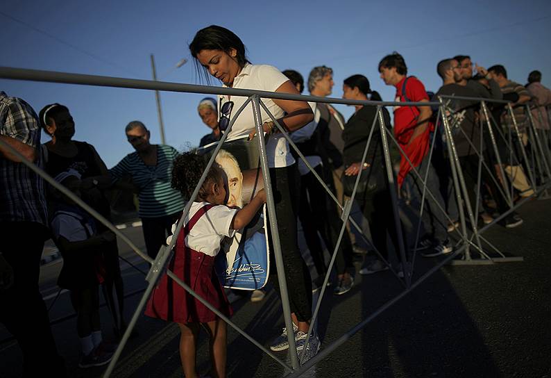 Гавана, Куба. Девочка в очереди целует протрет Фиделя Кастро во время панихиды