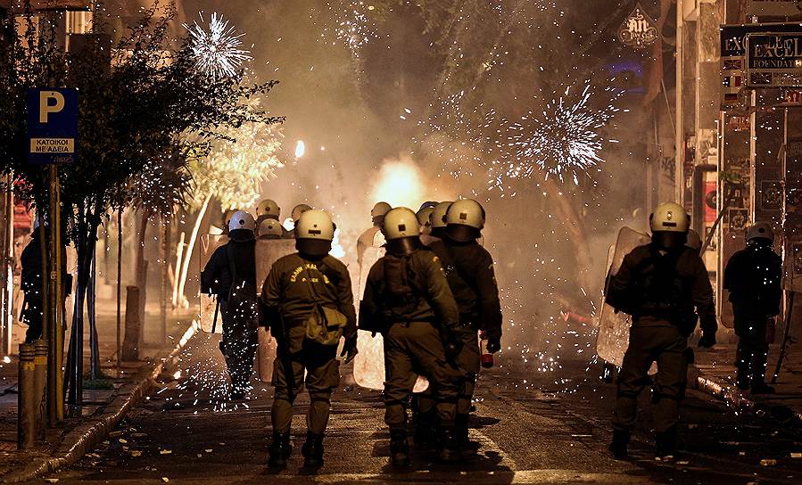Афины, Греция. Пожарные и полицейские во время протестов, начавшихся в городе после шествия в честь восьмой годовщины убийства подростка полицейскими