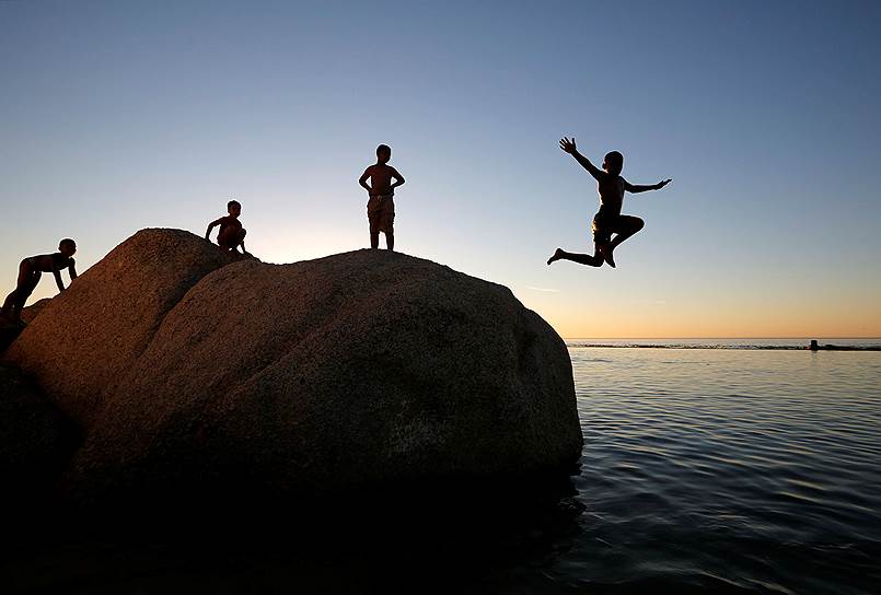 Кейптаун, ЮАР. Дети прыгают с камня в море 