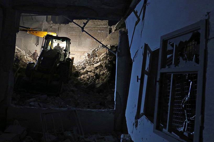 Идлиб, Сирия. Члены организации «Белые каски» расчищают завалы после ночной бомбардировки в районе, контролируемом оппозиционными силами 
