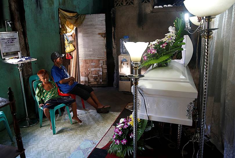 Манила, Филиппины. Родственники местного жителя, застреленного полицейскими в ходе нарковойны, скорбят