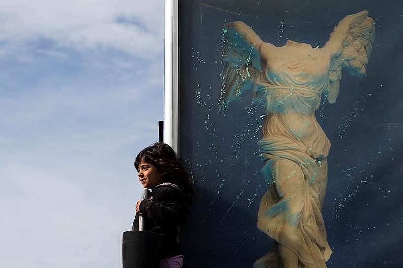 Афины, Греция. Девочка на фоне изображения богини Ники во время протеста мигрантов в бывшем аэропорту Эллиникон
