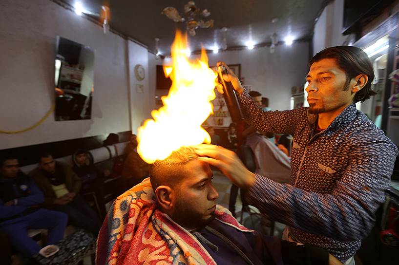 Рафах, Палестина. Парикмахер использует огонь для стрижки клиентов 