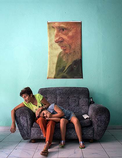 Третье место в категории &quot;Люди. Одиночный снимок&quot; заняла фотокорреспондент «Ъ» Кристина Кормилицына с фотографией женщины с дочкой в полицейском участке города Сантьяго-де-Куба во время траурных мероприятий в память о лидере кубинской революции Фиделе Кастро