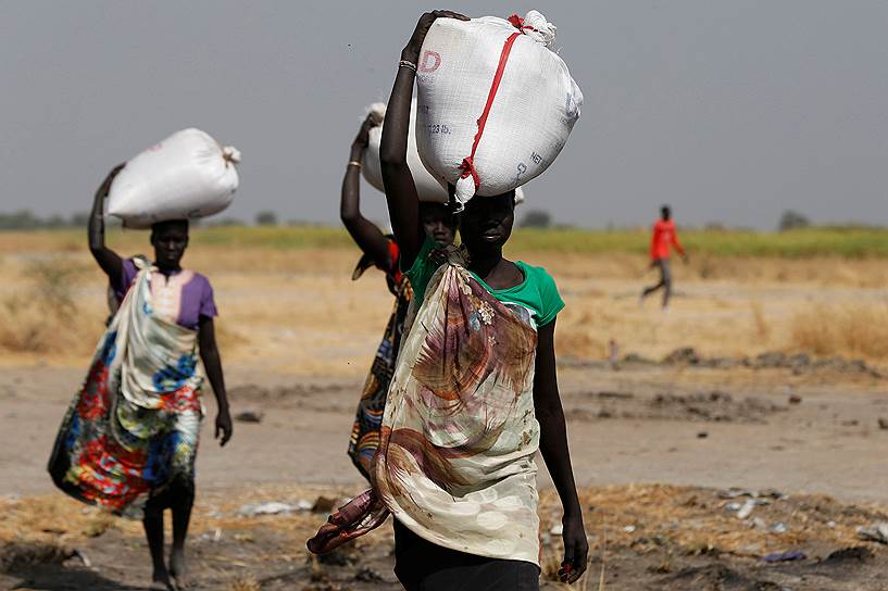 Провинция Вахда, Южный Судан. Женщины несут мешки с продуктами, которые они получили в качестве гуманитарной помощи