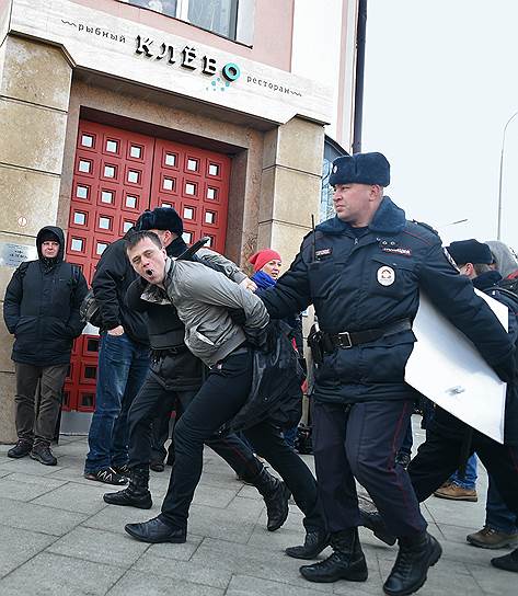 Сотрудники полиции во время задержания нарушителя общественного порядка на марше памяти Бориса Немцова в Москве