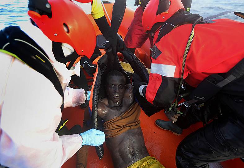 Средиземное море. Активисты организации Proactiva Open Arms вытаскивают из воды тело мертвого мигранта 