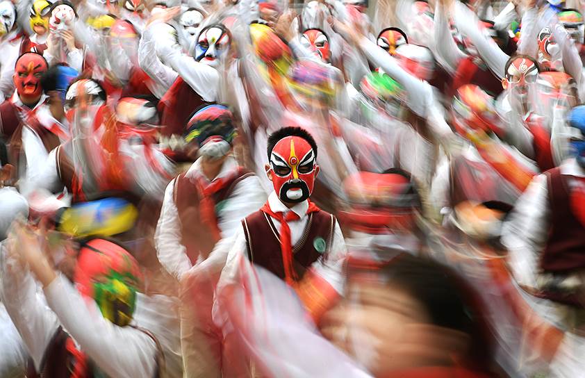 Ухань, Китай. Студенты в традиционных оперных масках занимаются физкультурой