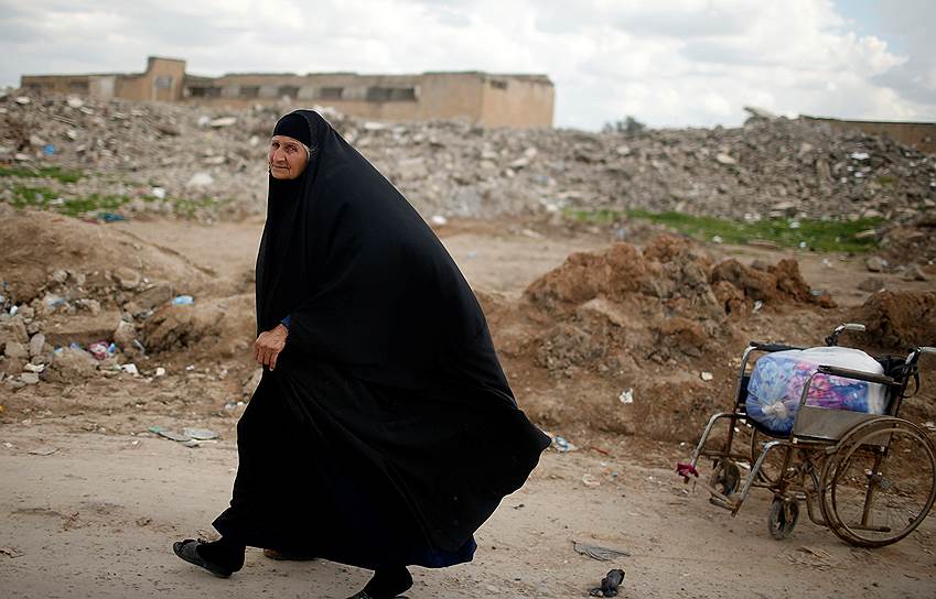 Хаммам-эль-Алиль, Ирак. Беженка из Мосула на фоне разрушенных зданий
