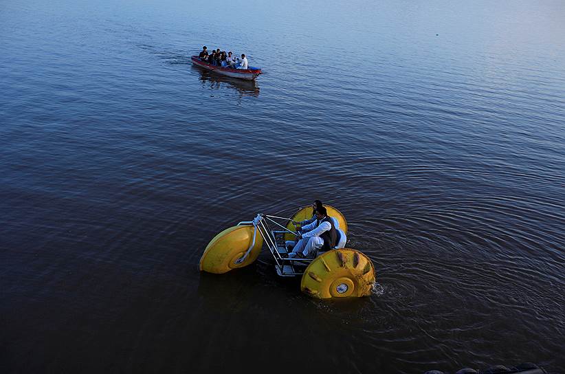 Исламабад, Пакистан. Местные жители на катамаране плывут по озеру Равал 