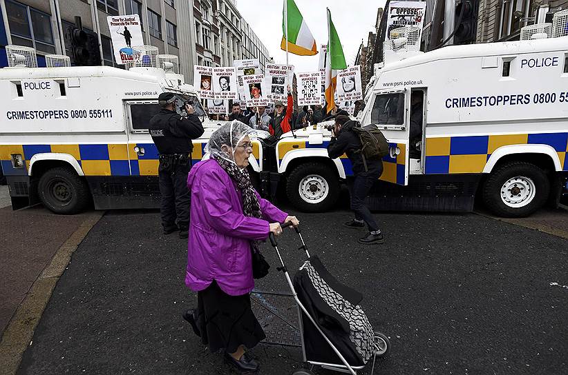 Белфаст, Великобритания. Женщина везет тележку на фоне акции бывших солдат, которые служили в Северной Ирландии