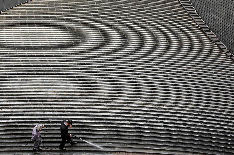 Пекин, Китай. Рабочие моют лестницу у одного из небоскребов