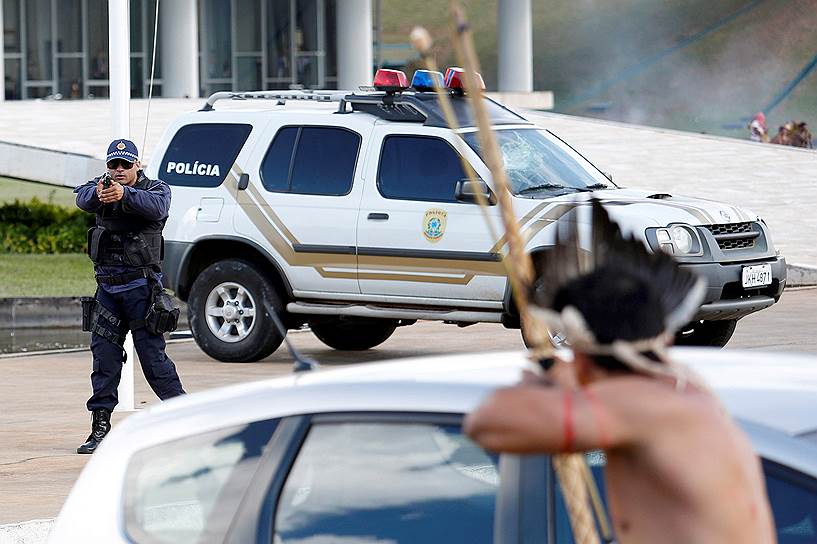 Бразилиа, Бразилия. Полицейский целится в индейца во время акции против нарушения прав коренных народов страны