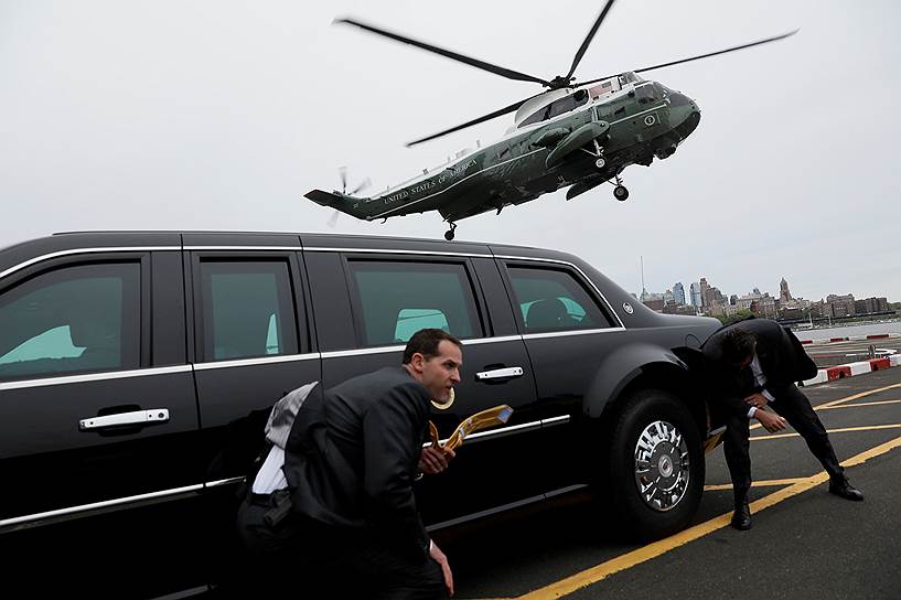 Нью-Йорк, США. Агенты секретной службы укрываются от ветра за президентским лимузином во время приземления вертолета Дональда Трампа 