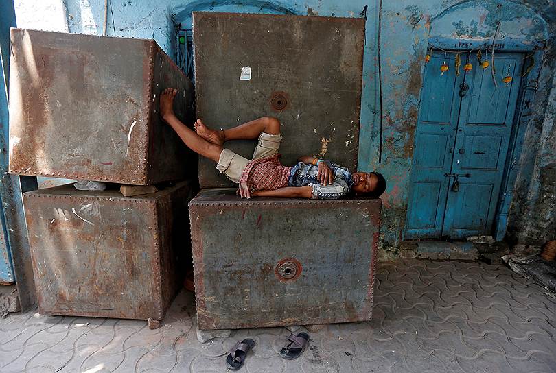 Калькутта, Индия. Местный житель на металлическом баке для воды