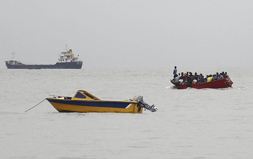 Читтагонг, Бангладеш. Катер перевозит людей с судна на берег перед тропическим штормом 