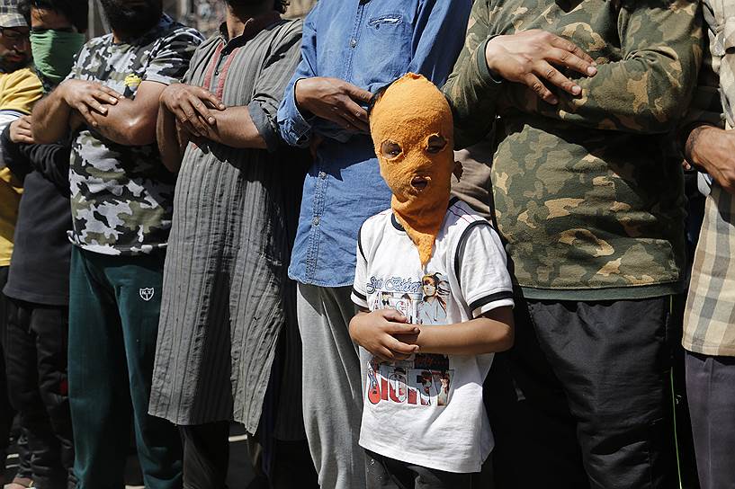 Сринагар, Индия. Ребенок в маске во время похорон убитого командира кашмирских повстанцев 

