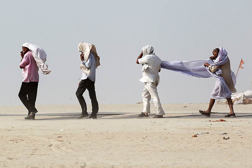 Аллахабад, Индия. Мужчины укрываются от порыва ветра на берегу реки Ганг
