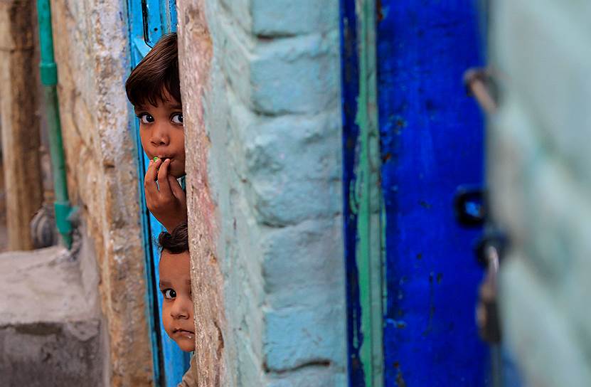 Исламабад, Пакистан. Дети выглядывают из двери своего дома