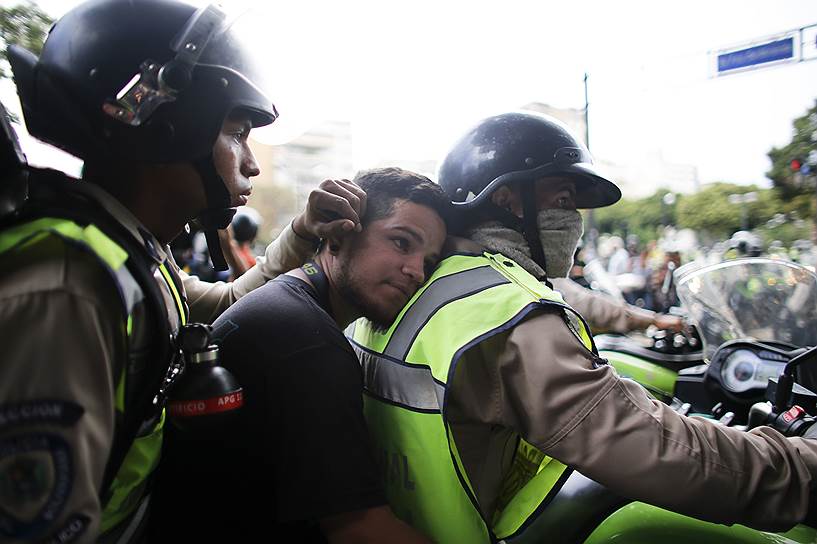 Каракас, Венесуэла. Полицейские ведут задержанных участников антиправительственной демонстрации