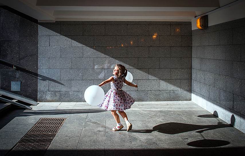 Москва, Россия. Девочка с воздушными шарами в подземном пешеходном переходе