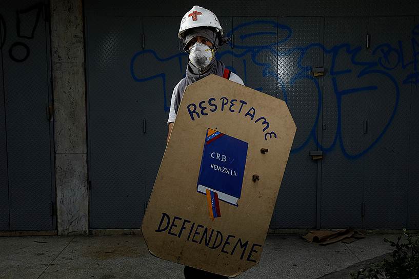 Протестующие уверены, что правительство нарушает конституцию Венесуэлы. На щите протестанта изображен главный документ страны и надпись «Уважайте меня»