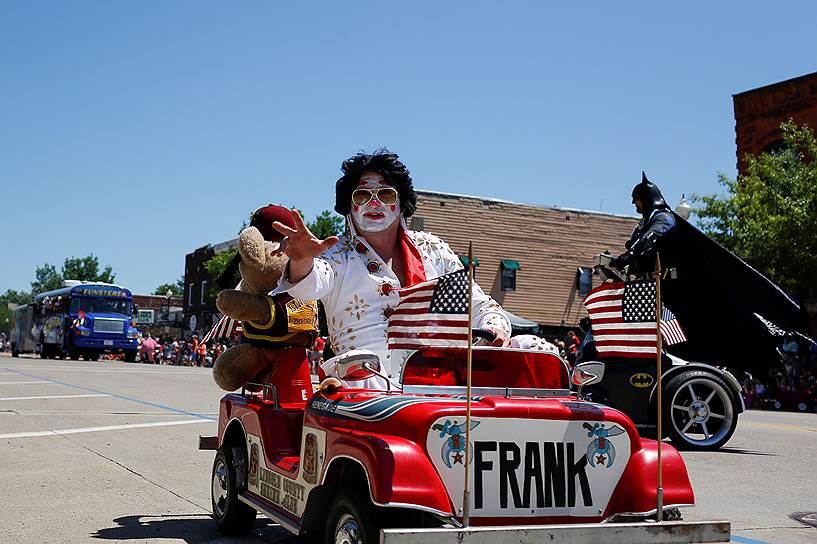 Томагавк, штат Висконсин. Человек в костюме Элвиса Пресли бросает конфеты зрителям на параде