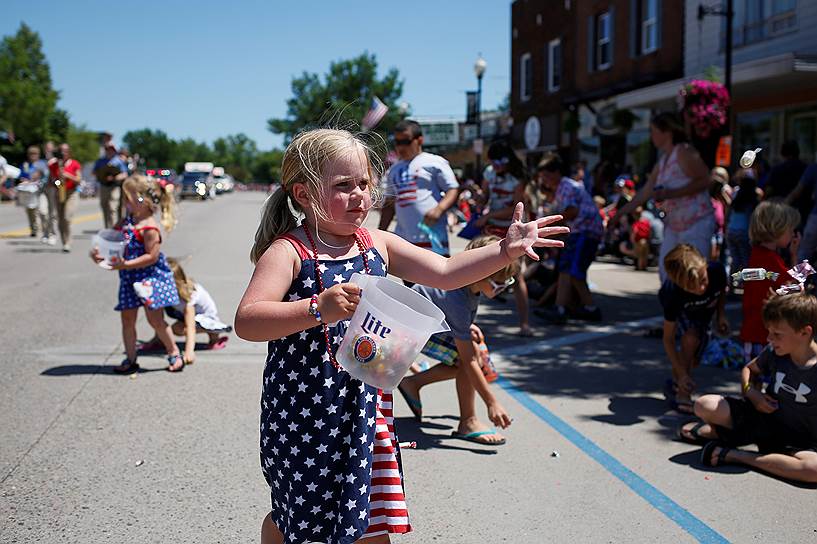 Томагавк, штат Висконсин. Девочка бросает конфеты зрителям на параде