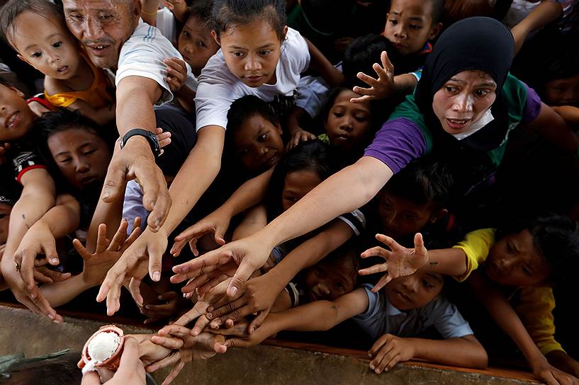 Марави, Филиппины. Беженцы стоят в очереди за мороженым, пока правительственные войска проводят в городе антитеррористическую операцию 
