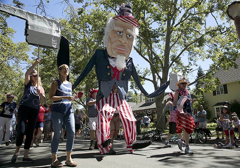 Сакраменто, штат Калифорния. Участники праздничного шествия несут куклу «дяди Сэма»
