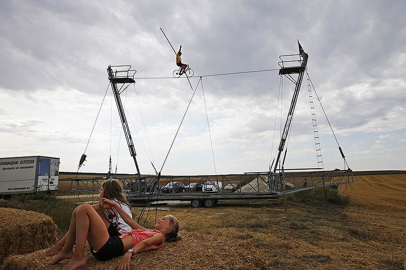 Труа, Франция. Канатоходец выполняет трюк, ожидая участников Tour de France 