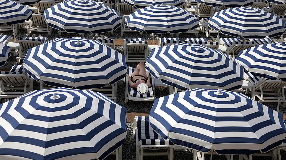 Ницца, Франция. Туристы укрываются от солнца под зонтами