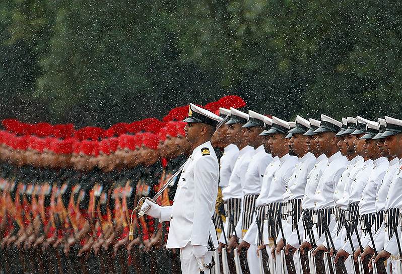 Нью-Дели, Индия. Индийские солдаты стоят под дождем во время торжественной церемонии в президентском дворце