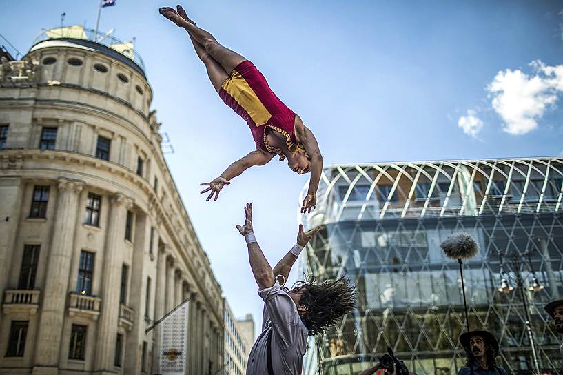 Будапешт, Венгрия. Член канадского цирка Eloize выполняет трюки во время флешмоба в поддержку нового шоу «Салон» 
