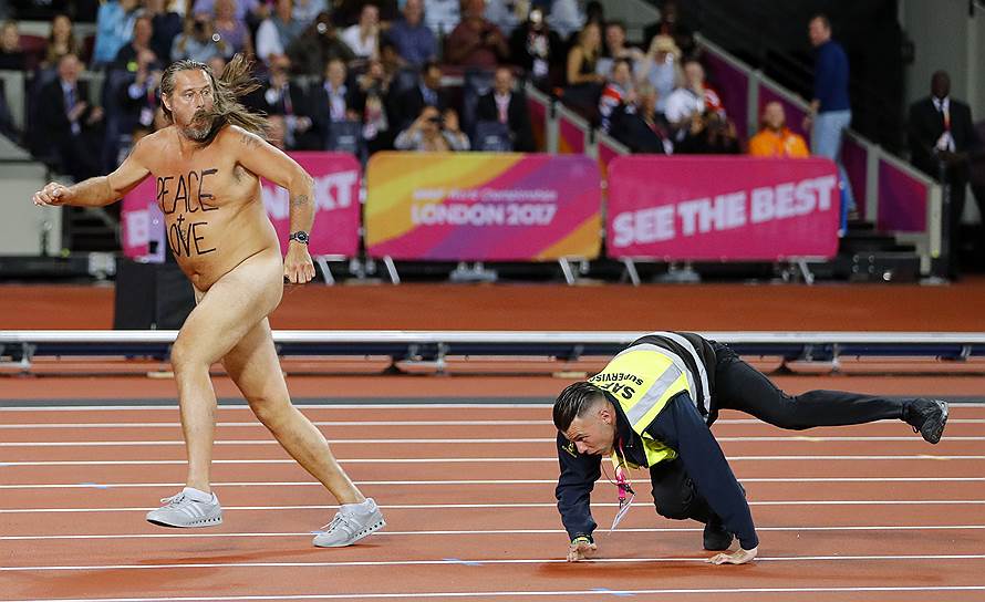 Лондон, Великобритания. Выбежавший на дорожку голый мужчина убегает от сотрудника стадиона во время проведения чемпионата мира по легкой атлетике