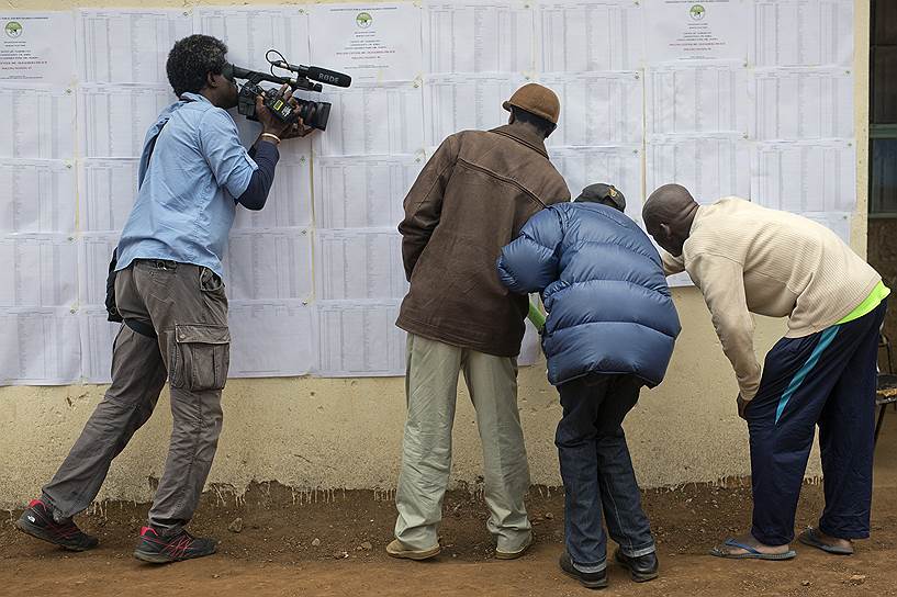 Найроби, Кения. Оператор снимает, как кенийцы проверяют наличие их имен в избирательных списках на участке для голосования в трущобе Кибера
