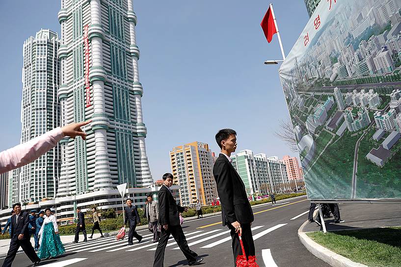 Люди на улице Ремен в Пхеньяне, где недавно был построен новый жилой комплекс