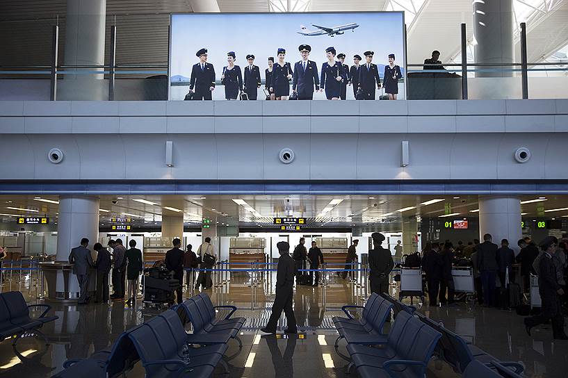Люди проходят паспортный контроль в аэропорте Пхеньяна