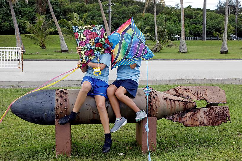 Остров Гуам, США. Школьники играют на торпеде времен Второй мировой в мемориальном парке