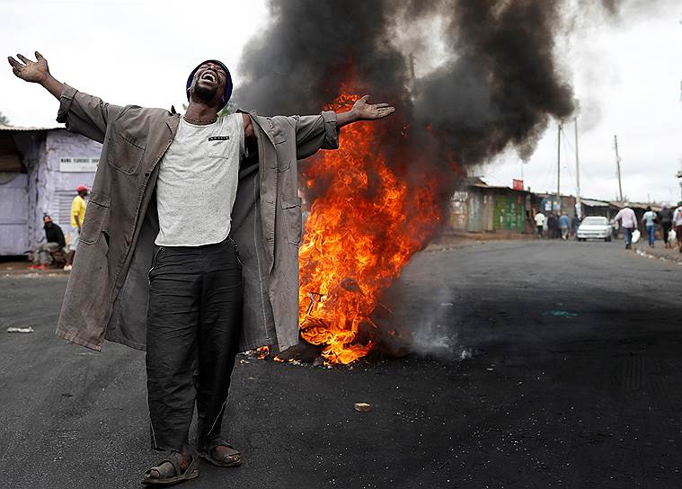 Найроби, Кения. Сторонник лидера оппозиции выступает перед сожженной баррикадой в трущобах Кибера