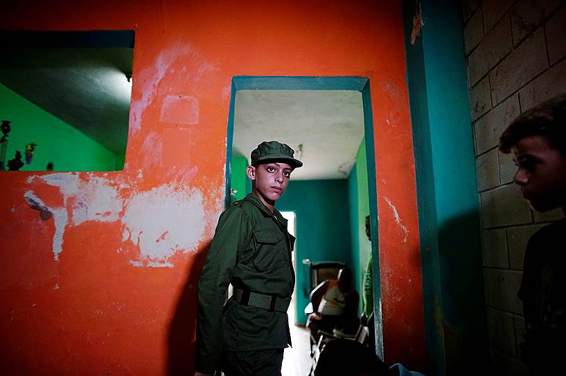 Сан-Антонио-де-лос-Баньос, Куба. 11-летний мальчик, одетый в военную форму, готовится к танцевальному выступлению в ходе торжеств, посвященных дню рождения Фиделя Кастро