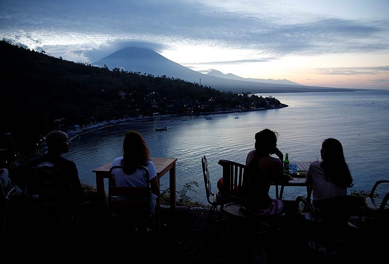 Бали, Индонезия. Туристы наблюдают закат солнца за вулканом Агунг