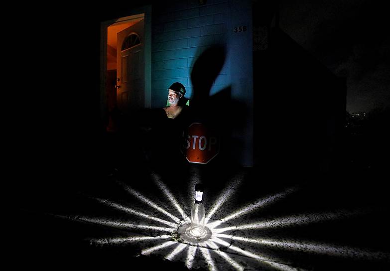 Крисченстед, Виргинские острова США. Местный житель пользуется светильником, аккумулирующим солнечную энергию, из-за нарушения электроснабжения после урагана «Мария»