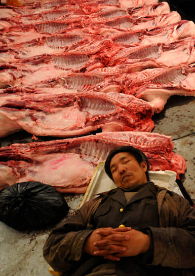 Продавец мяса на оптовом рынке свинины в Китае, 2008 год