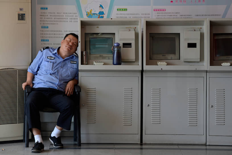 Охранник рядом с торговыми автоматами в китайском Тайюане, 2012 год