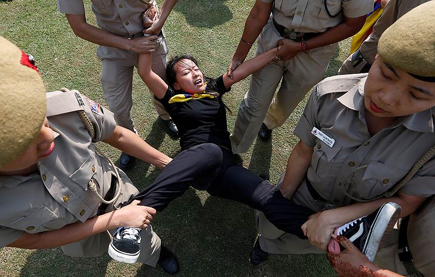 Пекин, Китай. Полиция задерживает жительницу Тибета, протестующую против избрания Си Цзиньпина председателем КНР на второй пятилетний срок  