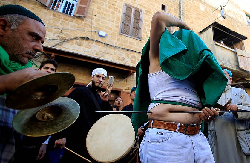 Сайда, Ливан. Последователь суфизма протыкает свое тело прутом во время ритуала самоистязания в честь рождения пророка Мухаммеда 