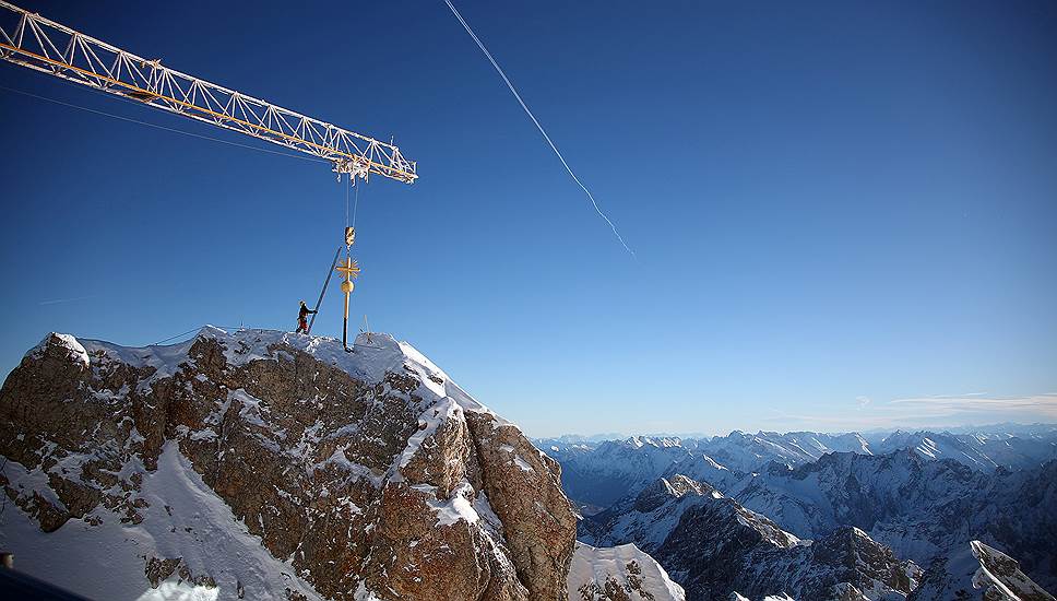 Гармиш-Партенкирхен, Германия. Рабочий закрепляет крест на вершине самой высокой горы в стране